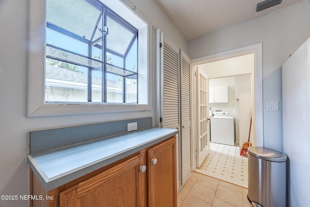 hall featuring washer / clothes dryer and a textured ceiling