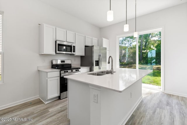 kitchen with plenty of natural light, light wood-type flooring, a kitchen island with sink, and stainless steel appliances