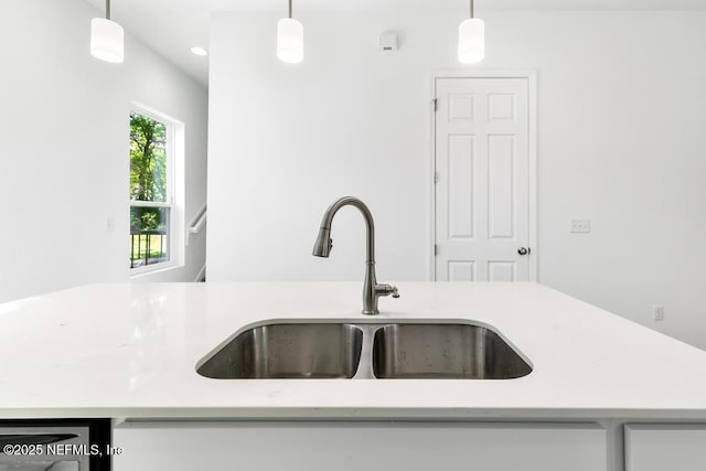 kitchen featuring recessed lighting, a sink, hanging light fixtures, and light countertops