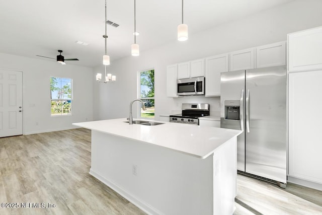 kitchen featuring visible vents, a sink, light wood-style floors, and appliances with stainless steel finishes