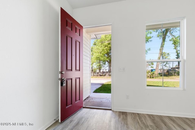 foyer entrance with baseboards and light wood finished floors