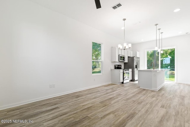 kitchen featuring a healthy amount of sunlight, stainless steel appliances, light wood-type flooring, and visible vents