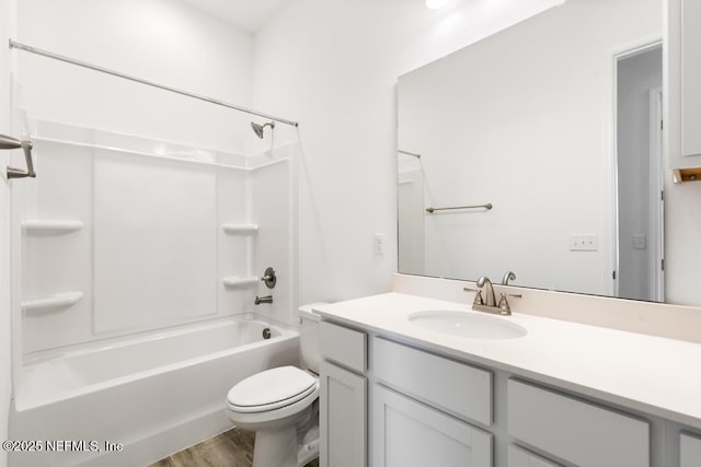 bathroom with vanity, toilet, wood finished floors, and tub / shower combination