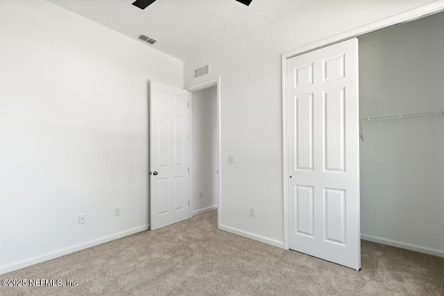 unfurnished bedroom featuring visible vents, carpet flooring, baseboards, and a closet