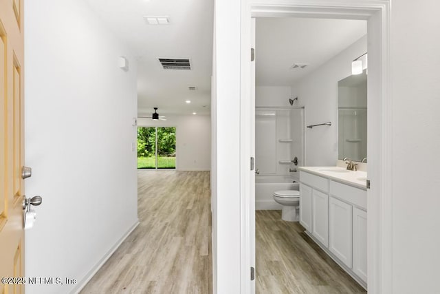 full bathroom with wood finished floors, visible vents, shower / bath combination, and vanity