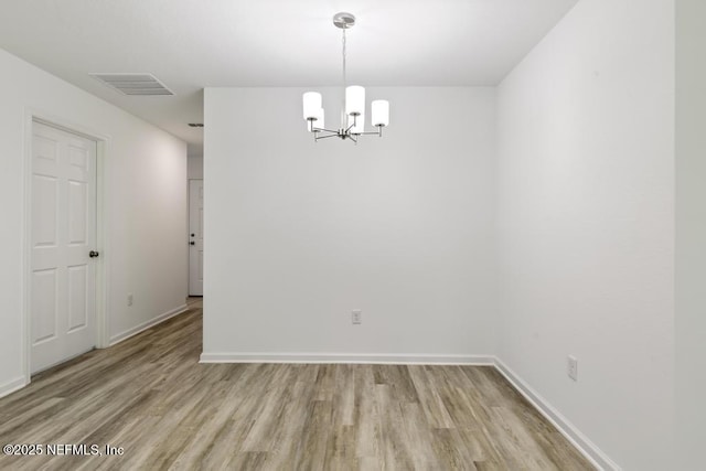 unfurnished dining area with baseboards, an inviting chandelier, visible vents, and light wood-type flooring