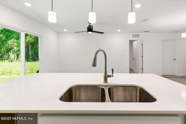 kitchen featuring a sink, visible vents, and light countertops