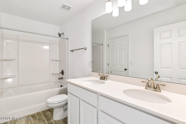 bathroom with wood finished floors, visible vents, a sink, and toilet