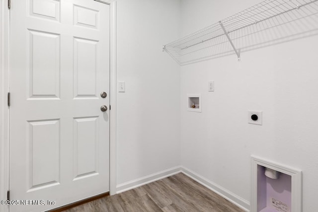 laundry room featuring wood finished floors, hookup for a washing machine, electric dryer hookup, baseboards, and laundry area