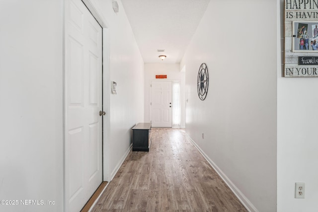 hall with baseboards and wood finished floors