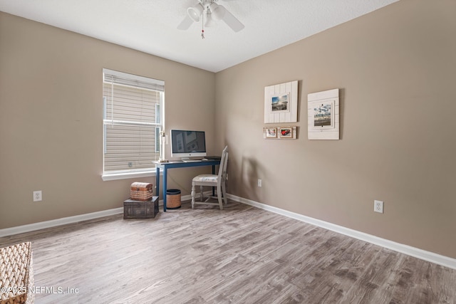 office space featuring baseboards, a ceiling fan, and wood finished floors