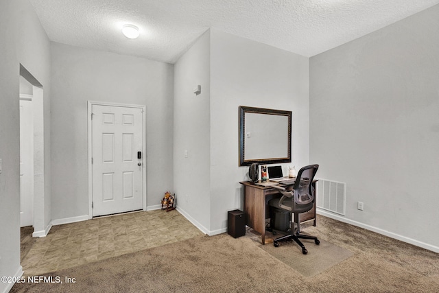 carpeted office featuring a textured ceiling, visible vents, and baseboards