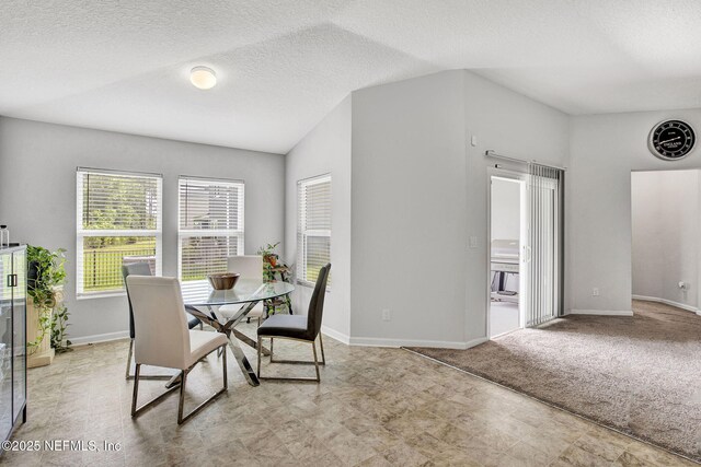 dining space with a textured ceiling and baseboards