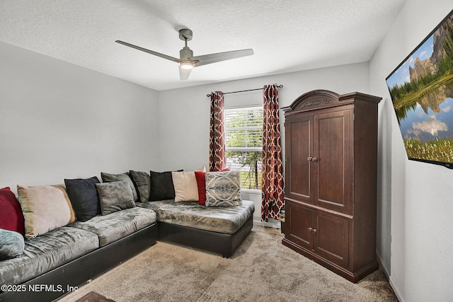 living room featuring a ceiling fan, light carpet, and a textured ceiling