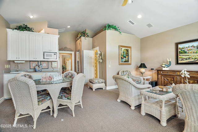 dining room with light carpet, baseboards, lofted ceiling, and a ceiling fan