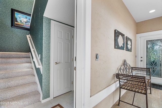 staircase featuring a textured wall and tile patterned floors