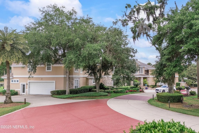 view of community featuring a garage and concrete driveway