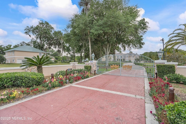 surrounding community featuring a gate and decorative driveway