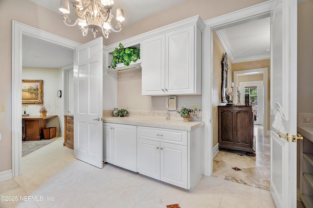 bar area featuring crown molding, a chandelier, baseboards, and hanging light fixtures