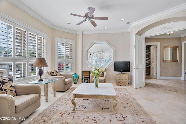 living room featuring ornamental molding, ceiling fan, baseboards, and arched walkways