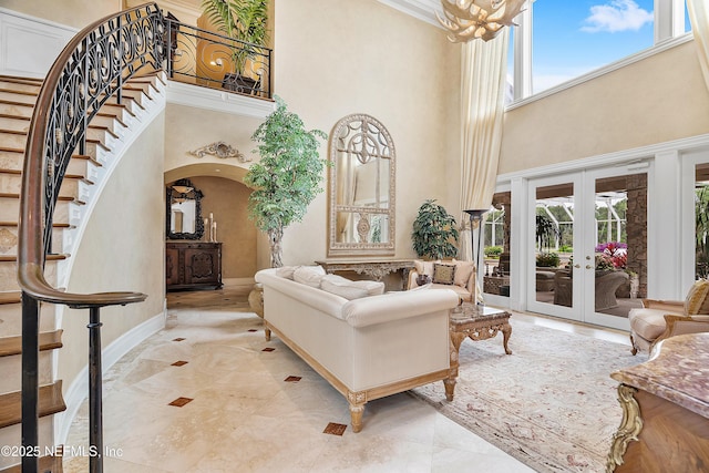 living room featuring a high ceiling, healthy amount of natural light, arched walkways, stairs, and french doors