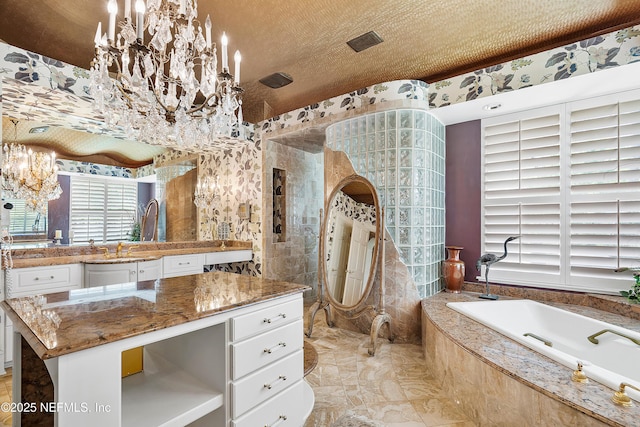 bathroom with a chandelier, a relaxing tiled tub, vanity, a textured ceiling, and marble finish flooring