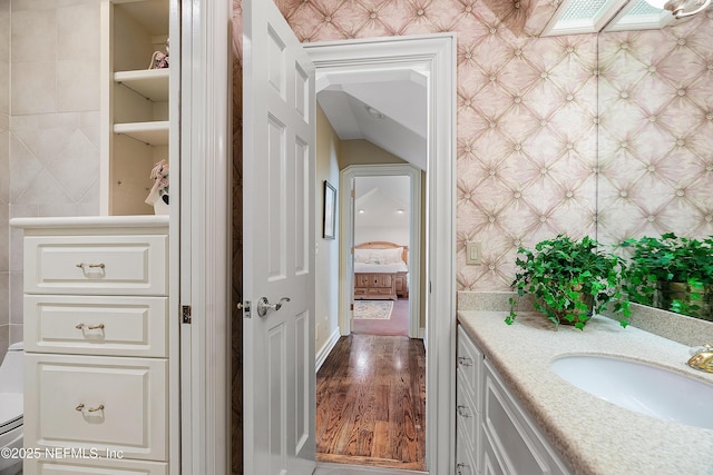 bathroom with tile walls, vanity, and wood finished floors