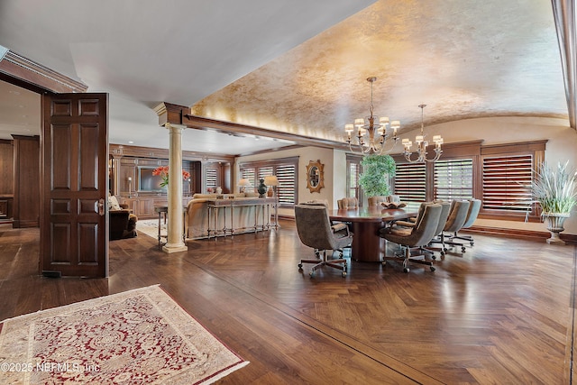 dining area featuring decorative columns, lofted ceiling, a chandelier, and baseboards