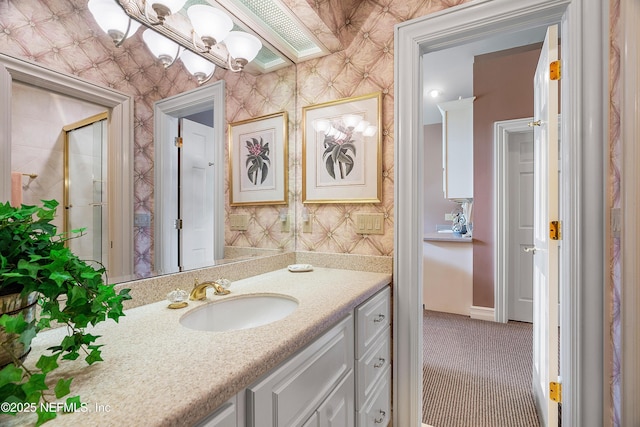 bathroom with vanity, a shower with shower door, and a chandelier
