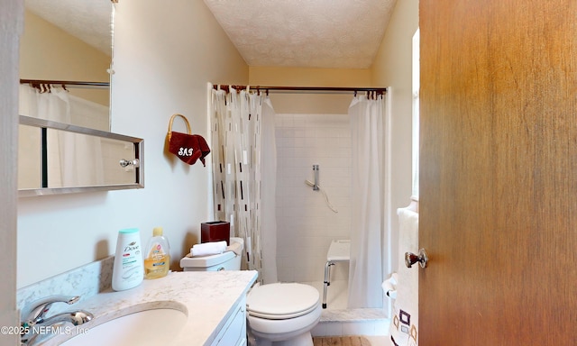 full bathroom with vanity, toilet, a textured ceiling, and a stall shower