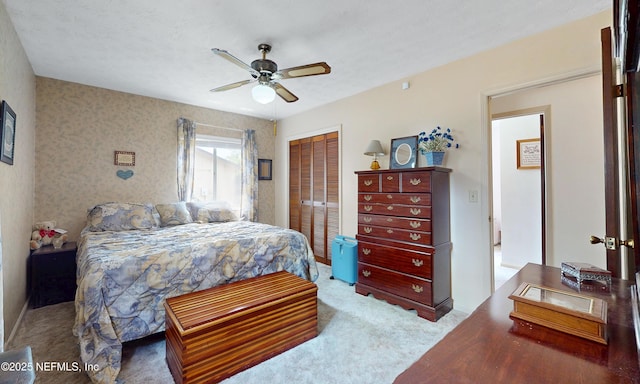 carpeted bedroom featuring a ceiling fan and a closet
