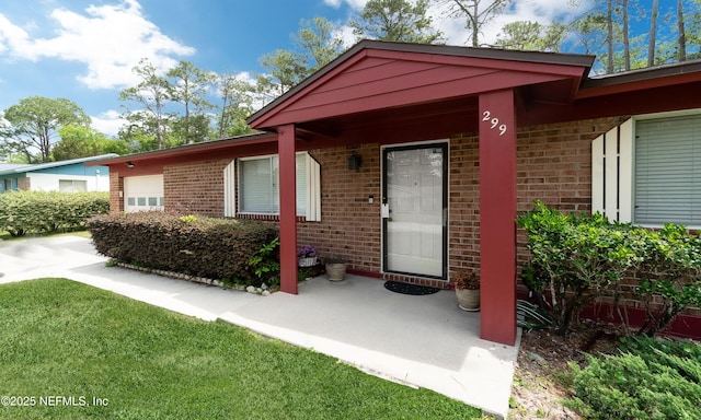 entrance to property with brick siding and a garage