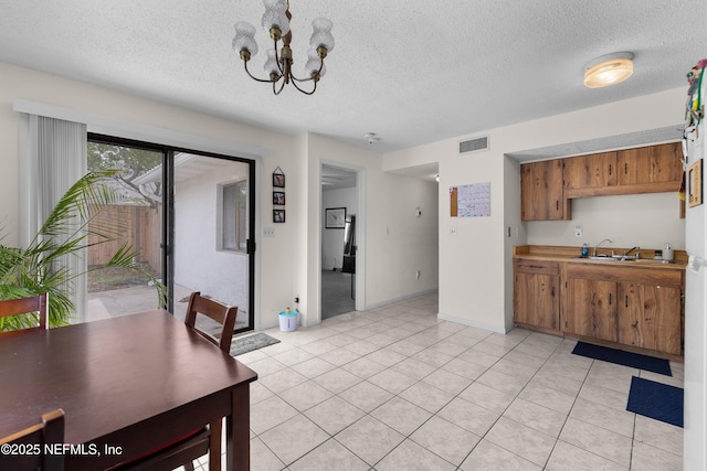 62 Atlantic Oaks Cir, Saint Augustine, FL 32080 - interior space featuring brown cabinetry, light tile patterned floors, visible vents, a notable chandelier, and a textured ceiling
