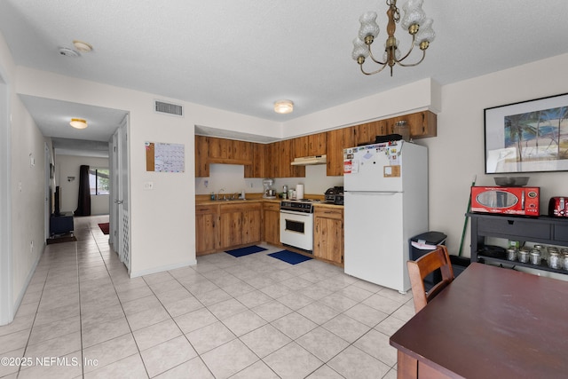 62 Atlantic Oaks Cir, Saint Augustine, FL 32080 - kitchen featuring a sink, visible vents, under cabinet range hood, an inviting chandelier, and white appliances