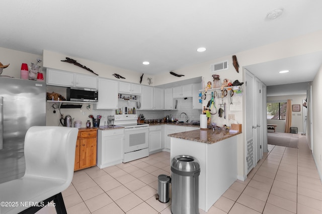 62 Atlantic Oaks Cir, Saint Augustine, FL 32080 - kitchen featuring stainless steel microwave, light tile patterned floors, visible vents, white cabinets, and electric range