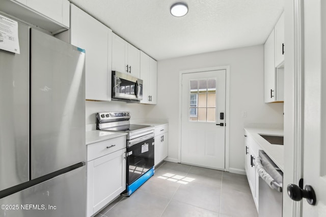 7843 India Ave, Jacksonville, FL 32211 - kitchen featuring light countertops, light tile patterned floors, white cabinets, and stainless steel appliances
