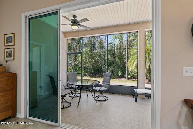 sunroom featuring outdoor dining area and a ceiling fan