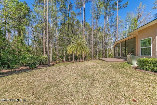 view of yard featuring ceiling fan and a sunroom