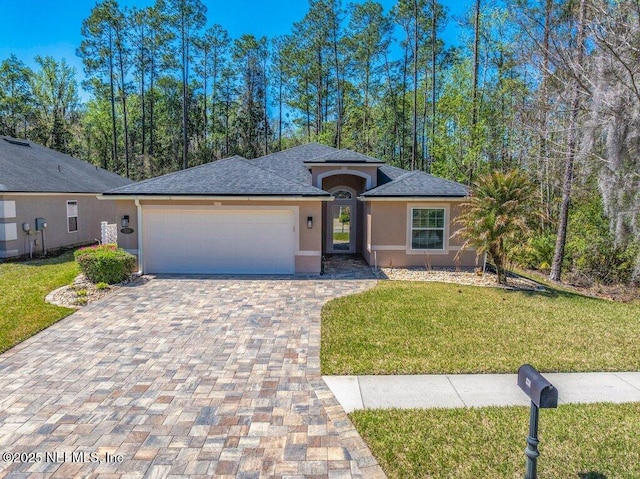 single story home featuring stucco siding, driveway, a front lawn, and a garage