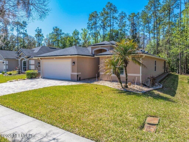 ranch-style home featuring decorative driveway, an attached garage, a front lawn, and stucco siding
