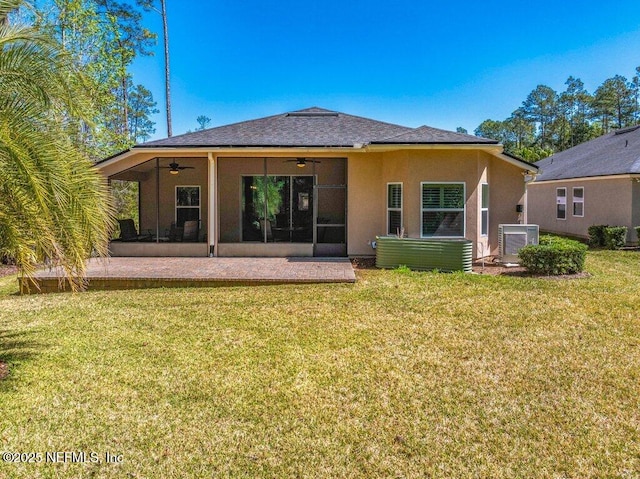 back of property with ceiling fan, a lawn, a sunroom, central AC, and stucco siding
