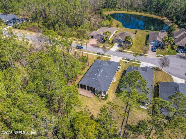 drone / aerial view featuring a water view and a wooded view