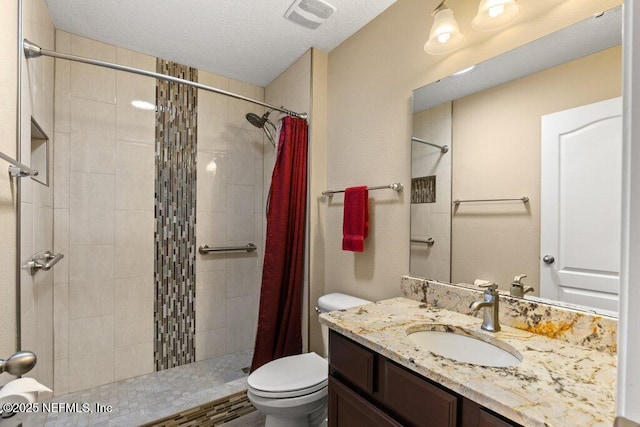 full bath with vanity, toilet, tiled shower, and visible vents