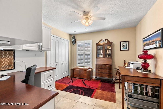 office space featuring light tile patterned floors, ceiling fan, and a textured ceiling