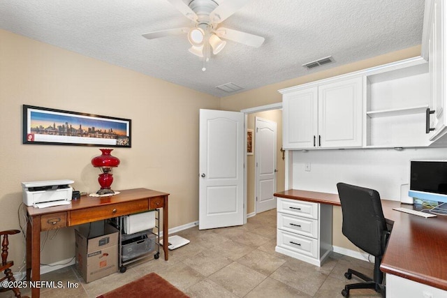 office space with a textured ceiling, ceiling fan, visible vents, and baseboards
