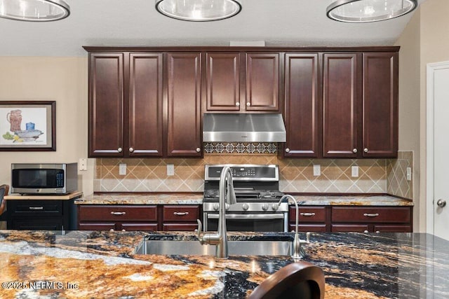 kitchen with decorative backsplash, exhaust hood, stainless steel appliances, and dark stone countertops
