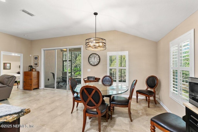 dining room with a notable chandelier, lofted ceiling, light tile patterned flooring, and visible vents