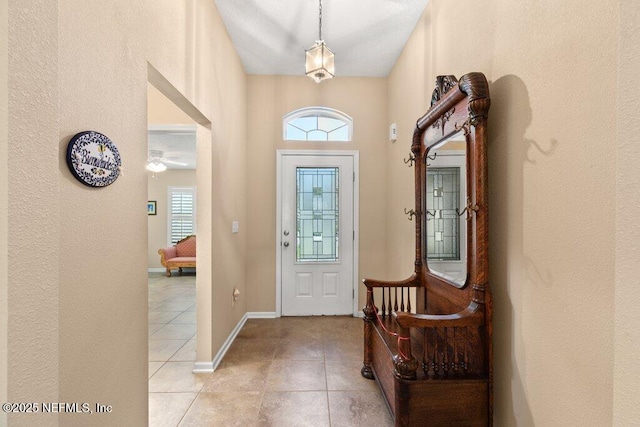 entryway with light tile patterned floors and baseboards