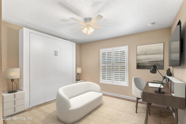 home office featuring a textured ceiling, ceiling fan, and baseboards