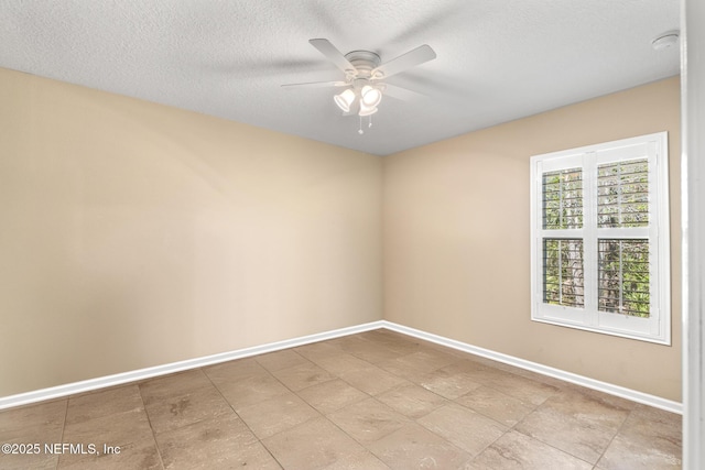 spare room with baseboards, ceiling fan, and a textured ceiling